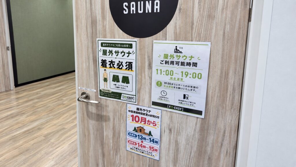 フィットイージー瑞浪店の屋外サウナの掲示。利用時間11時から19時と着衣必須の案内